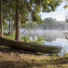 Tranquil watercolor scene: Boats by serene lake, lush trees