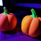 Vibrant stylized pumpkins under purple lighting