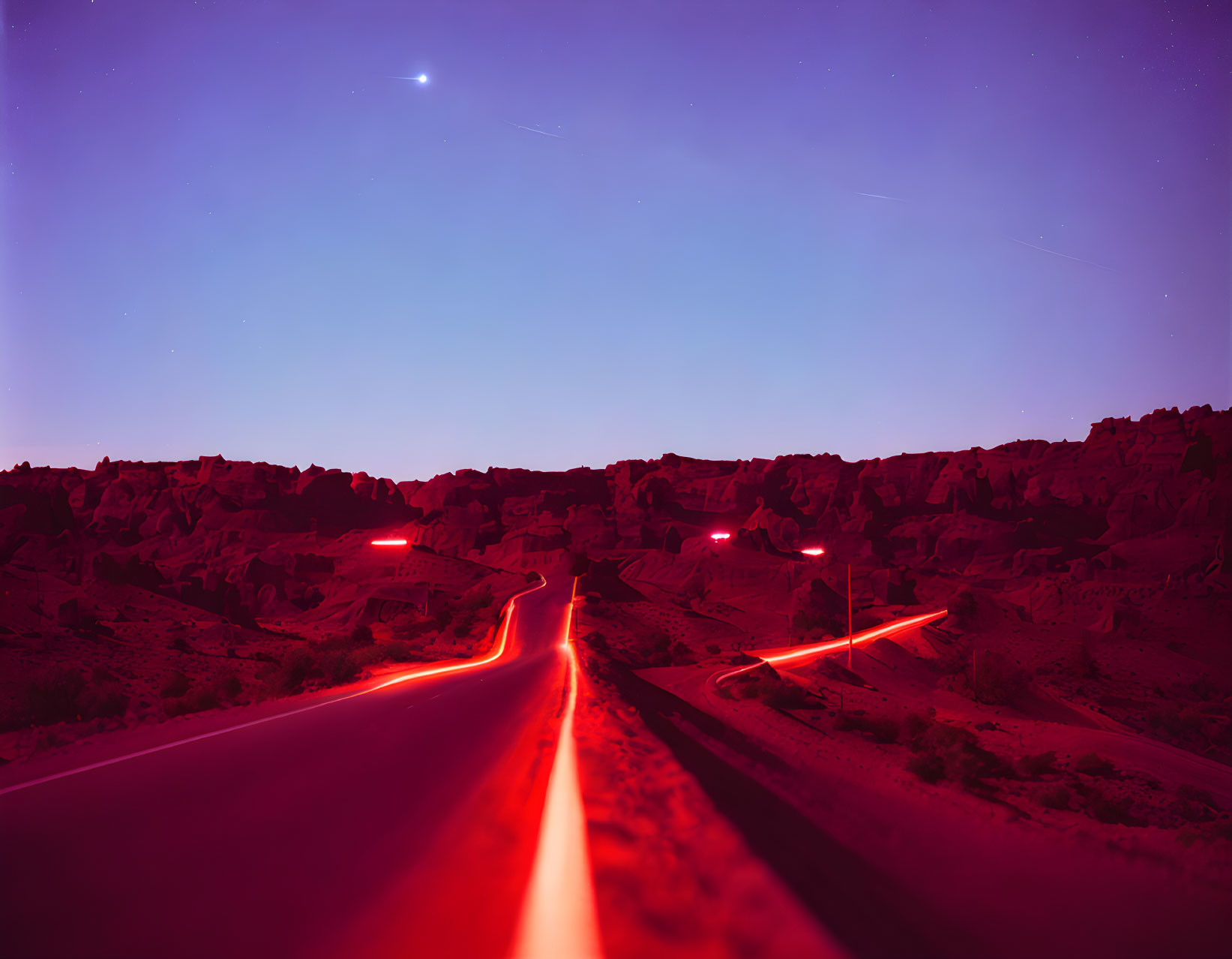 Night Scene: Long Exposure Light Trails on Winding Road in Rocky Landscape