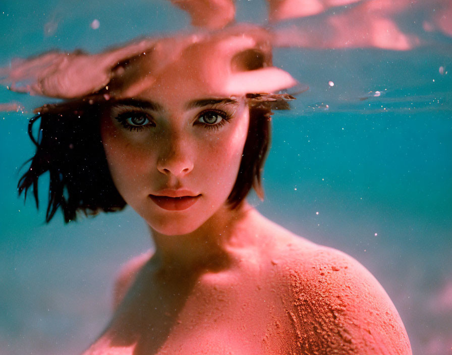 Woman with Striking Eyes Submerged in Turquoise Water