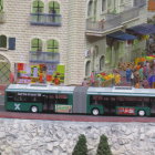 Colorful Miniature Buses by Stone Building with Autumn Foliage