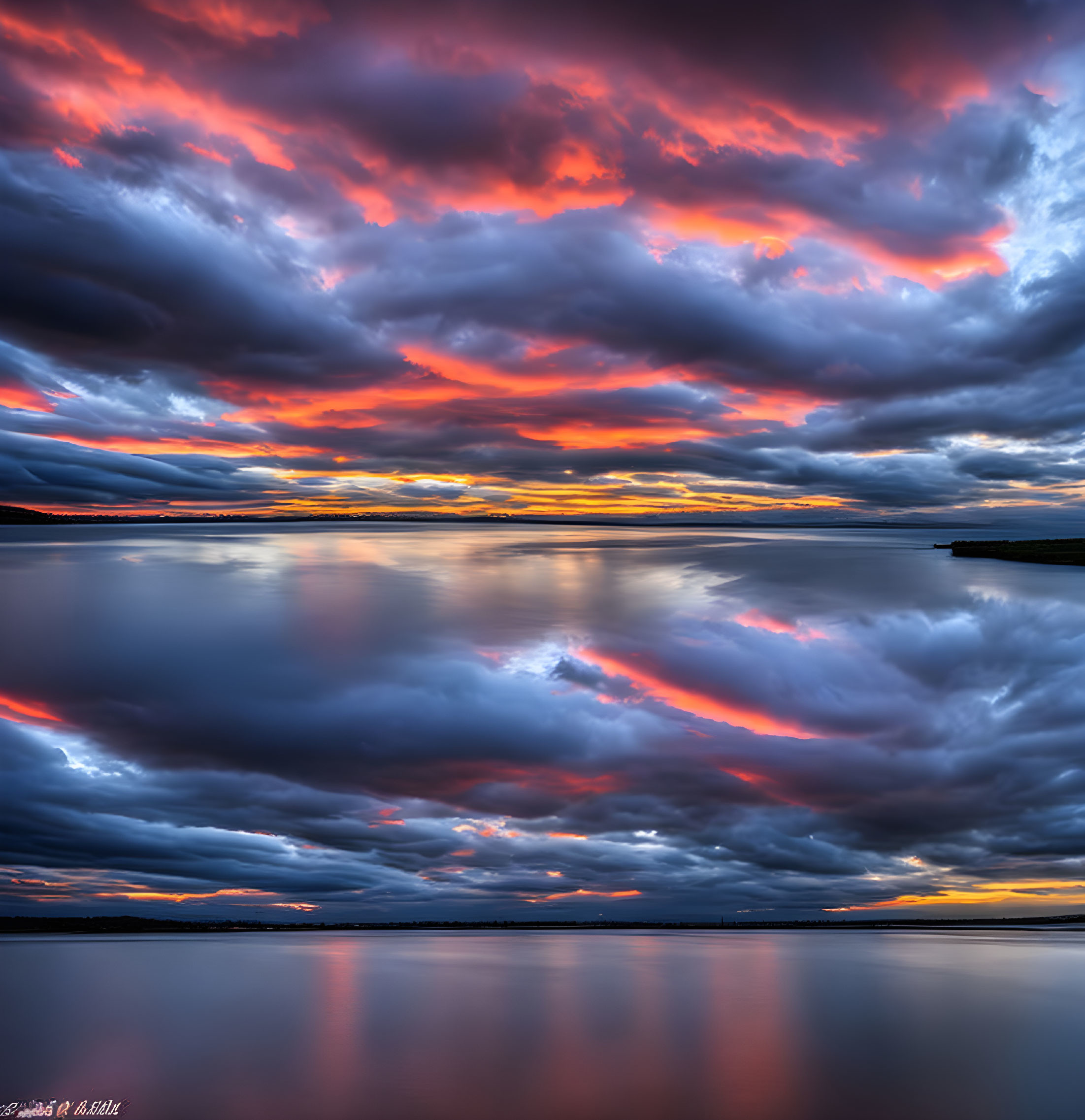 Vivid sunset reflected on tranquil water surface