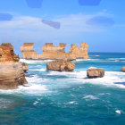 Coastal limestone stacks with turbulent blue sea and cloudy sky