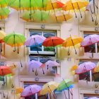 Vibrant umbrellas above European-style architecture on sunny day