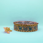 Ornate Box with Gold Leaf and Pearls on Teal Fabric surrounded by Golden Leaves