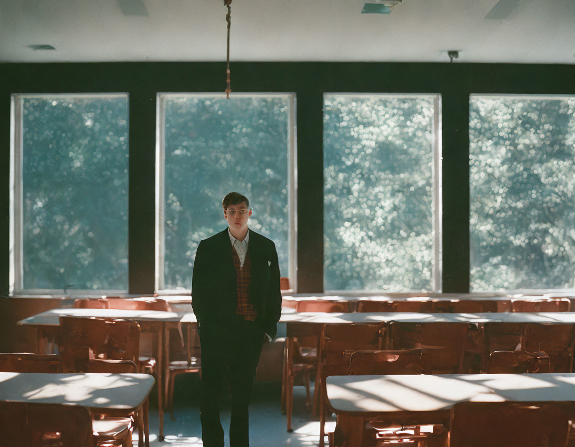 Sunlit classroom with person facing camera and lush greenery outside