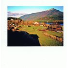 Colorful landscape poster with hills, mountains, and structure under pastel sky