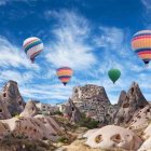 Vibrant hot air balloons over rustic house and rock formations