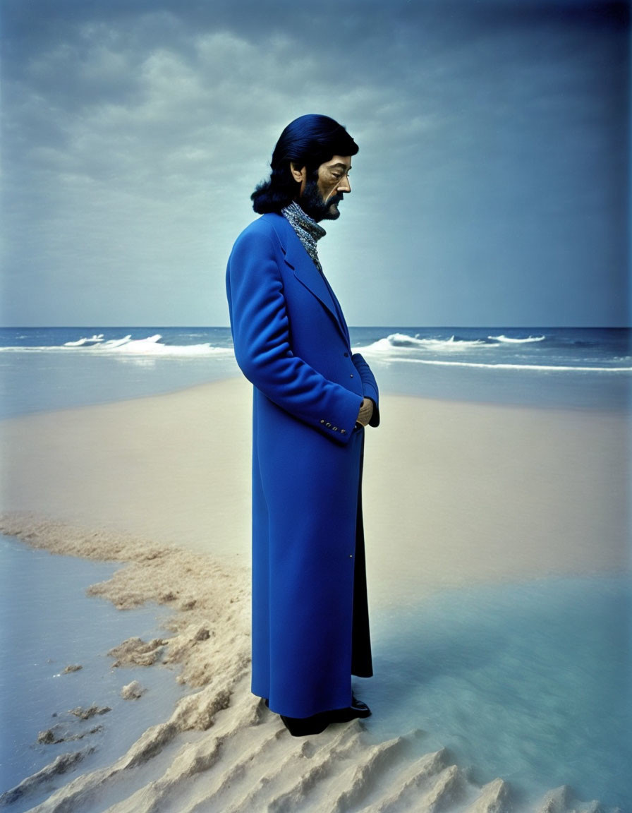 Bearded man in glasses on beach with waves and cloudy sky