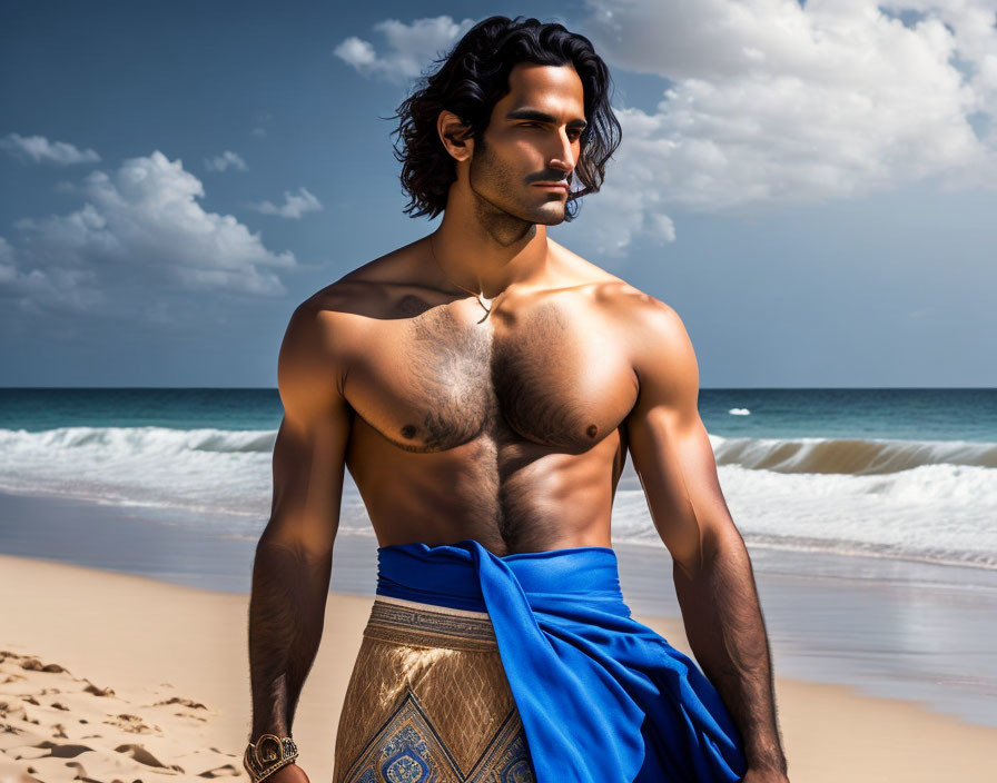 Shirtless man with long hair on beach in blue sarong