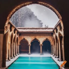 Tranquil pool and symmetrical columns in arched cloister with historic building and clear sky