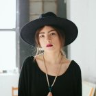 Woman in Black Witch's Hat Painting on White Background