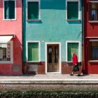 Colorful Houses and Canoe Reflected in Still Water with Lily Pads