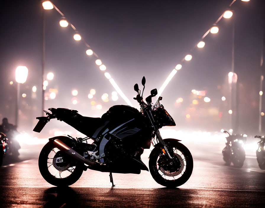 Foggy night motorcycle silhouette with glowing streetlights