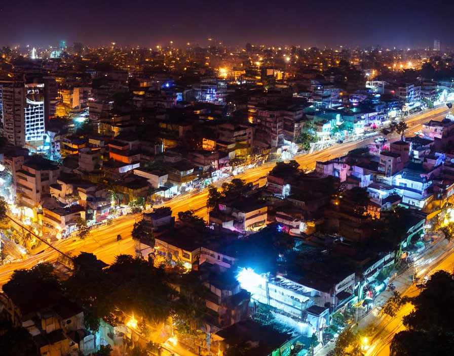 Nighttime cityscape with illuminated streets, cars, lit buildings, and urban skyline.