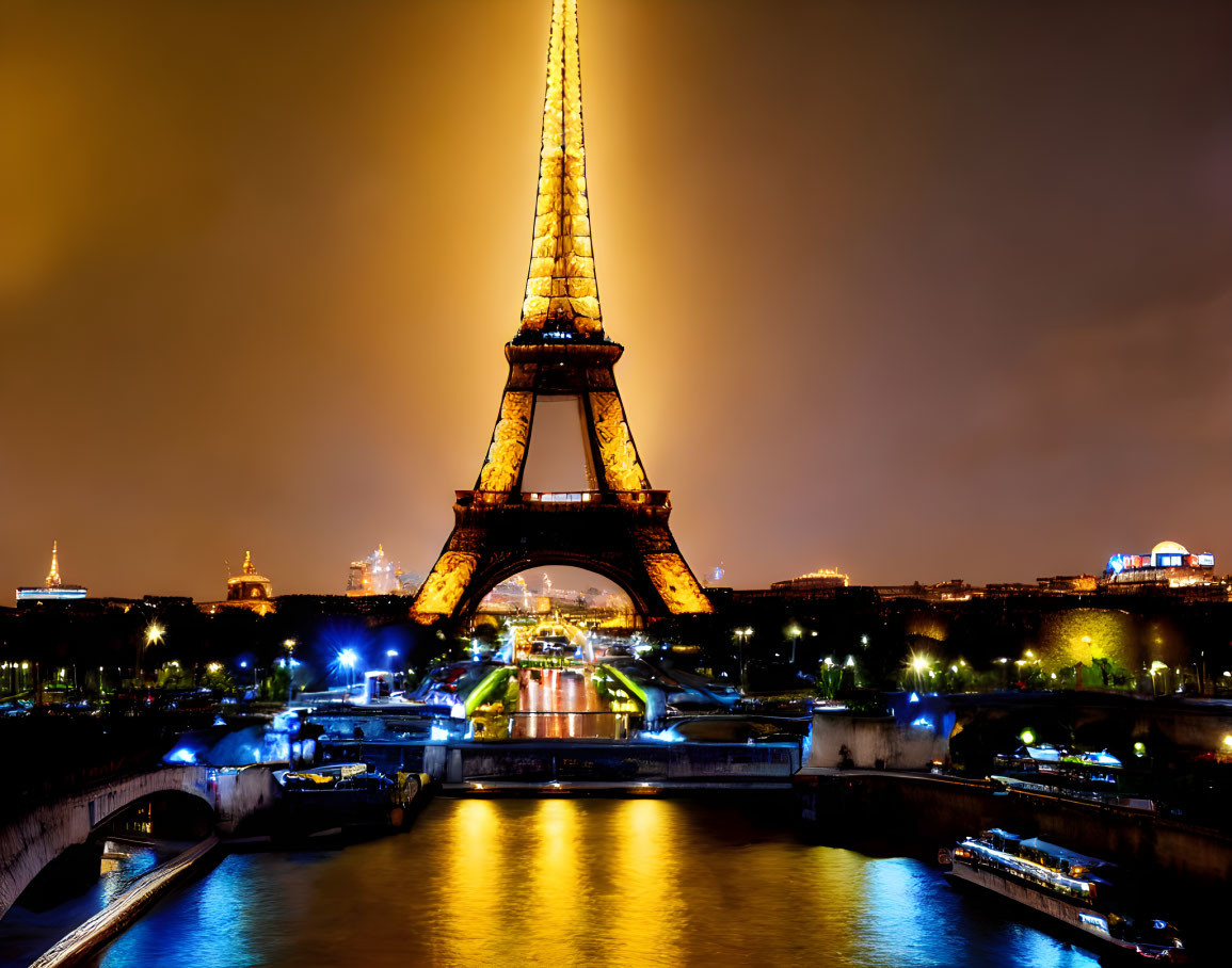 Eiffel Tower Illuminated at Night with City Lights and River Reflections