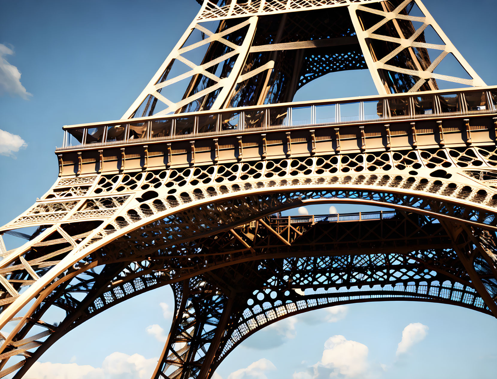 Detailed view of Eiffel Tower ironwork under blue sky.