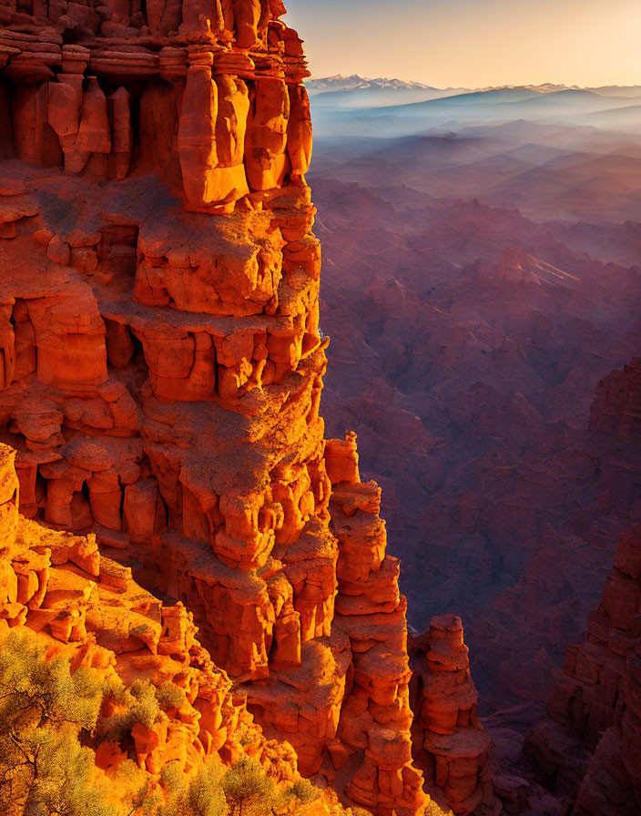 Vibrant red rock formations at sunset with hazy blue mountains