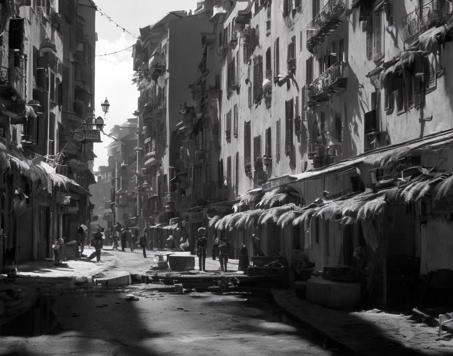 Monochrome photo of narrow old street with traditional buildings and hanging laundry