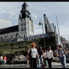 Colorful cityscape painting: train at platform with bustling crowd & futuristic skyline