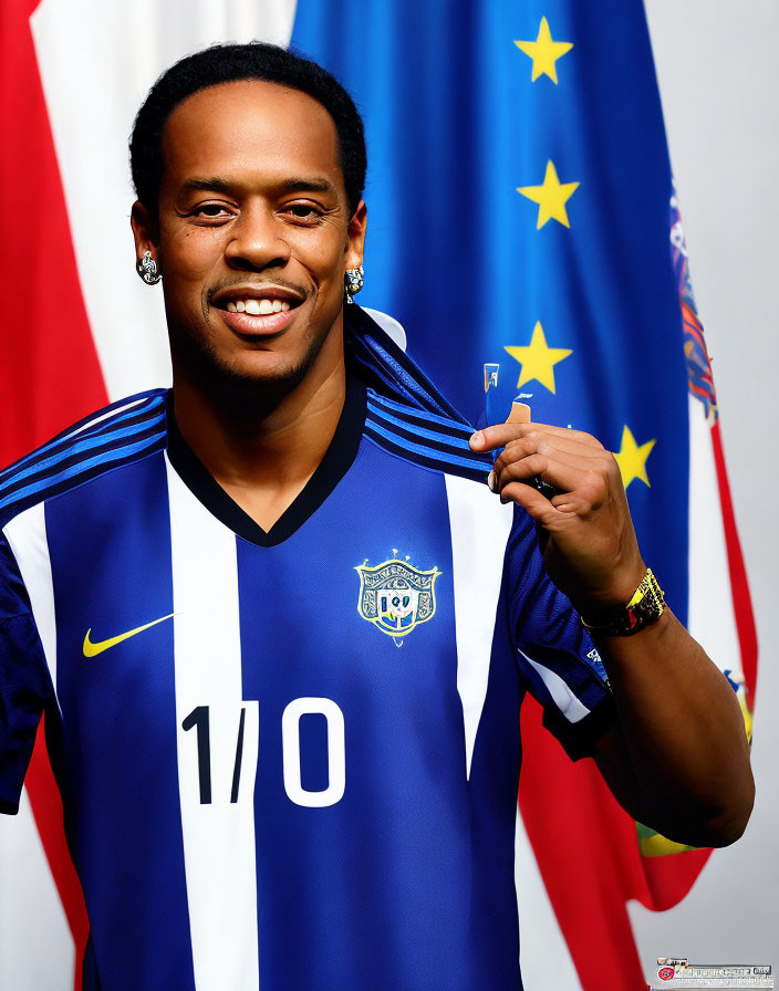 Smiling person holding sports jersey with number 10 against flag backdrop