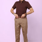 Fit man in stylish gold pants against pink background