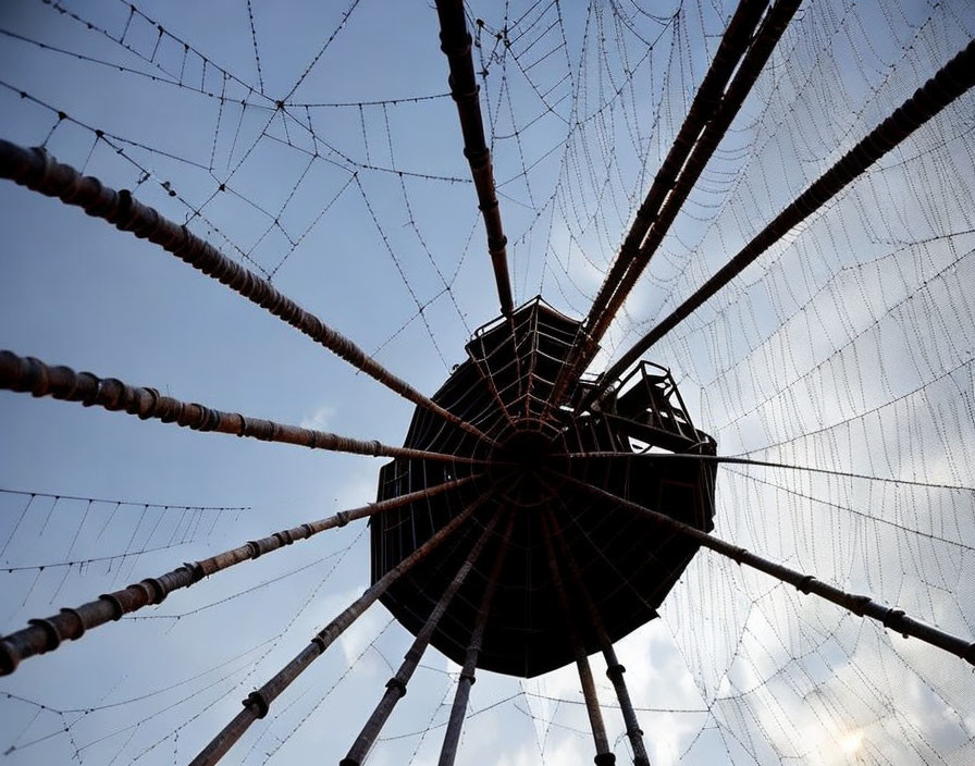 Circular structure with radiating cables under cloudy sky