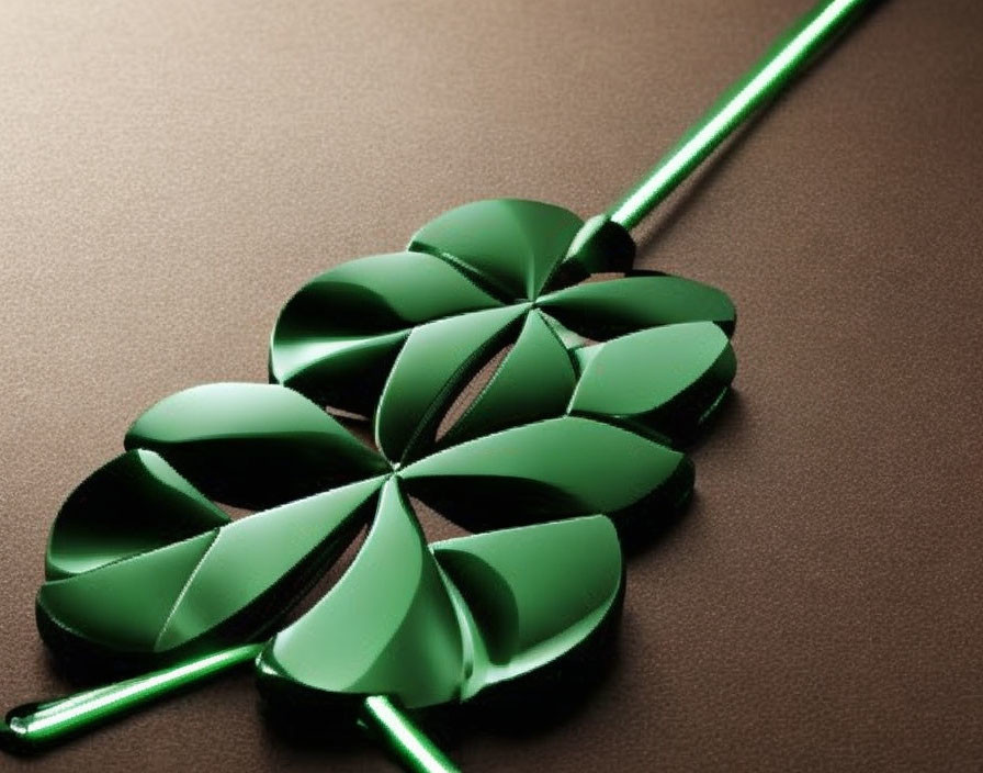 Green metallic shamrock on brown surface with soft light reflection