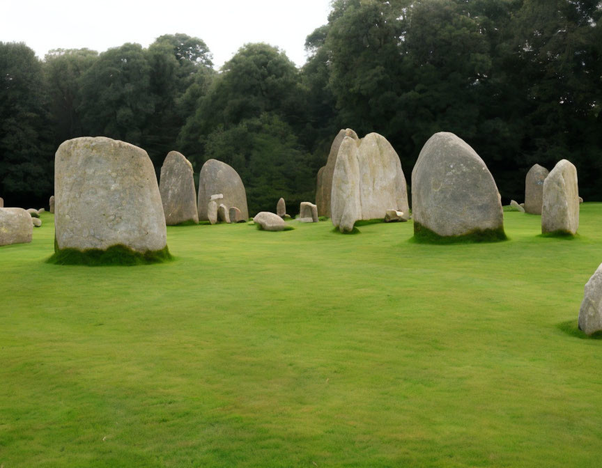 Ancient standing stones on grassy field with trees under overcast sky