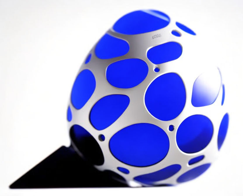 White spherical object with blue circular cutouts on light background