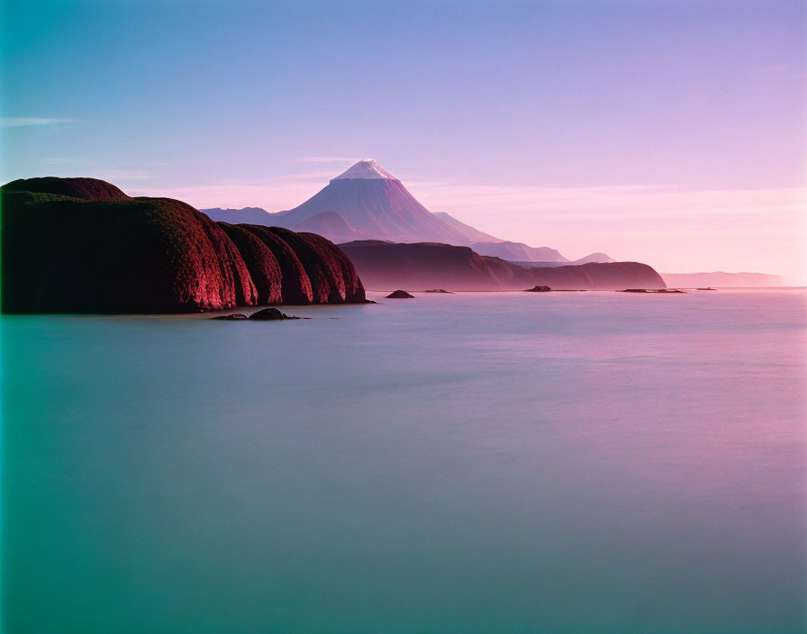 Tranquil seascape with distant mountain at sunrise or sunset