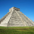 Digital artwork: Pyramid with castle, figures, and mountains under clear sky