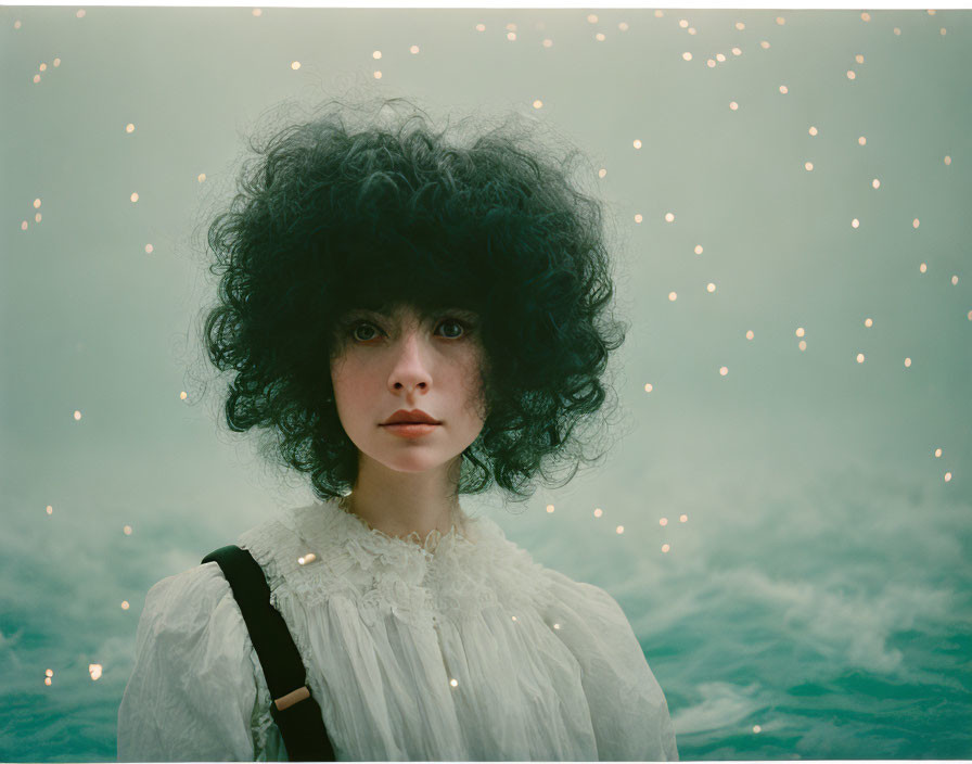 Curly Haired Woman in White Blouse with Misty Background