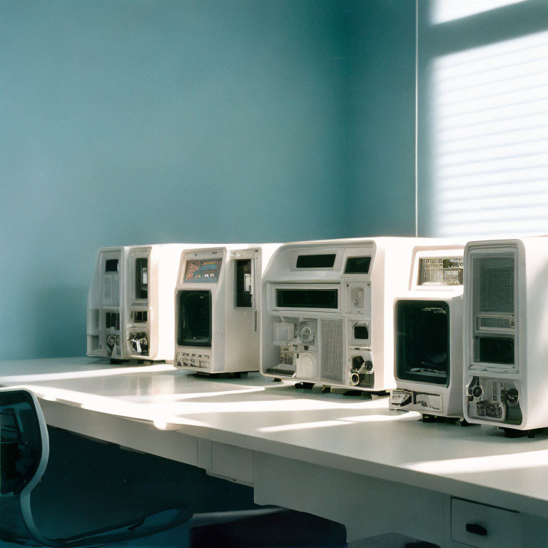 Vintage Computers with CRT Monitors on Table in Room with Blue Walls