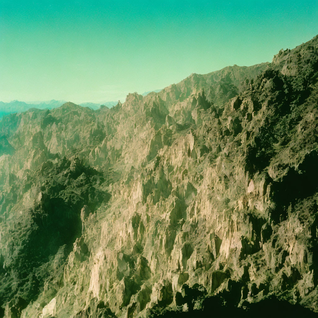 Scenic mountain peaks with lush greenery under clear blue sky