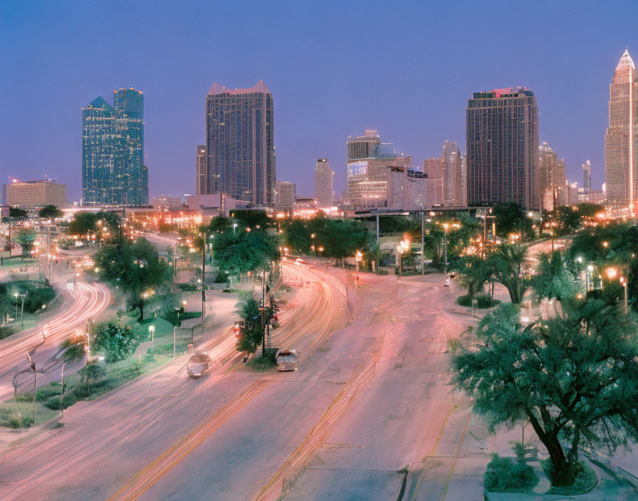 Cityscape at Twilight: Light Trails, High-rise Buildings, and Greenery