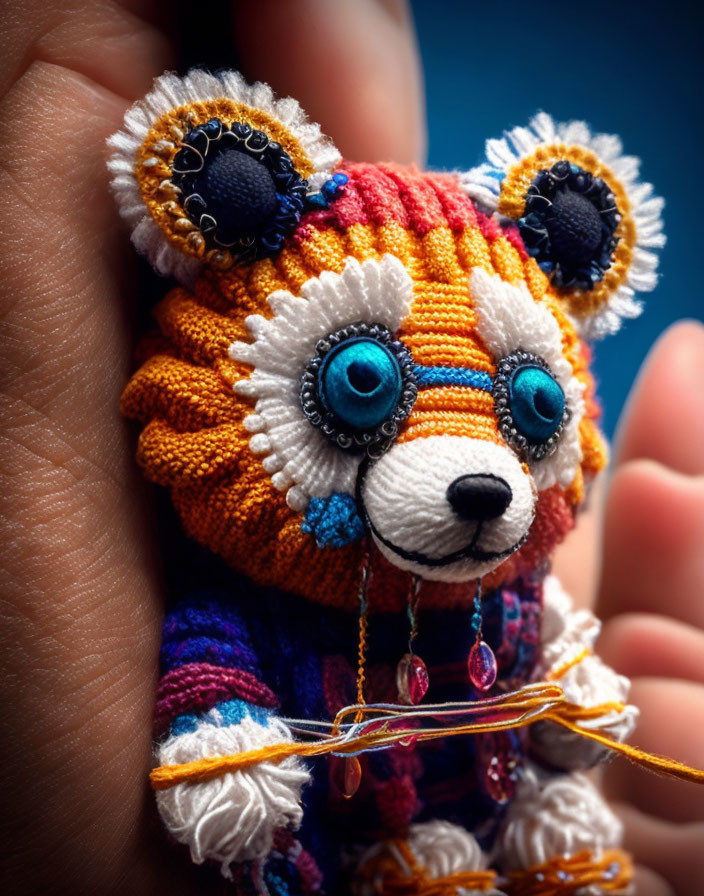 Colorful Handcrafted Toy Bear with Intricate Patterns and Large Blue Eyes Being Held