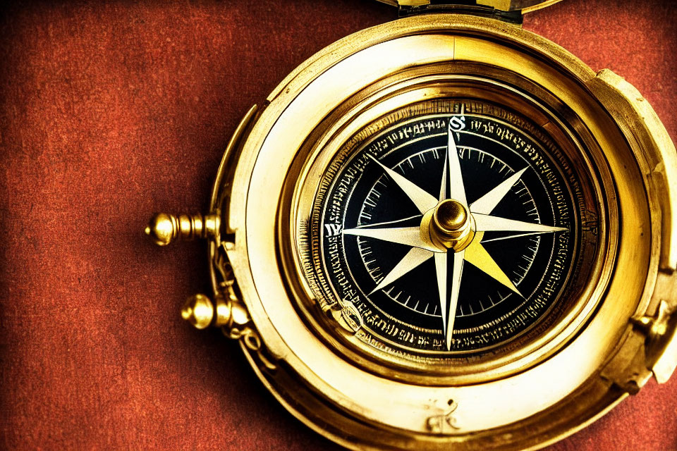 Vintage Brass Compass on Maroon Textured Background