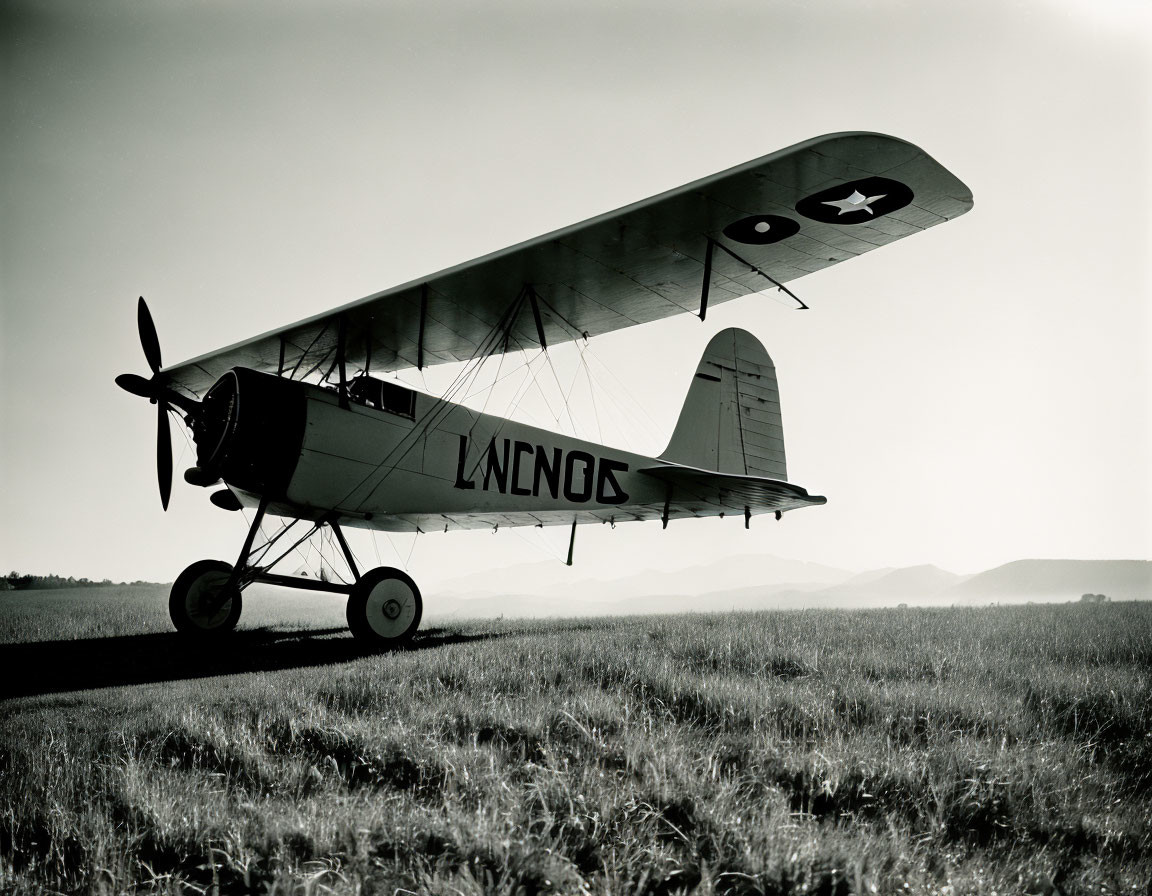 Vintage Biplane with U.S. Roundel Insignia on Grass Field