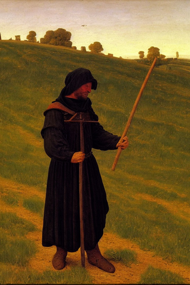 Medieval monk in black robes holding wooden crucifix in green field