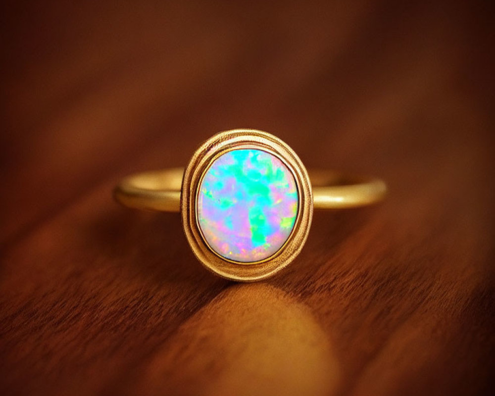 Gold Ring with Luminous Opal on Wooden Surface