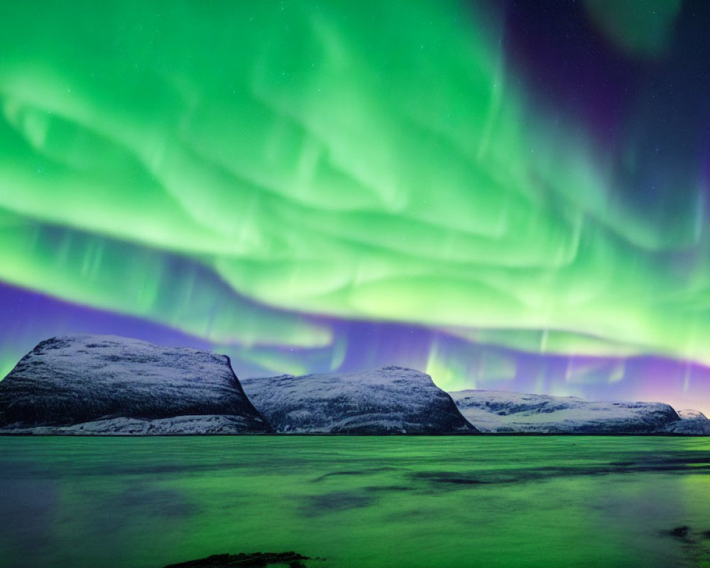 Majestic green aurora borealis over snow-capped mountains