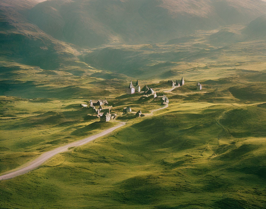 Scenic view of small village on rolling green hills