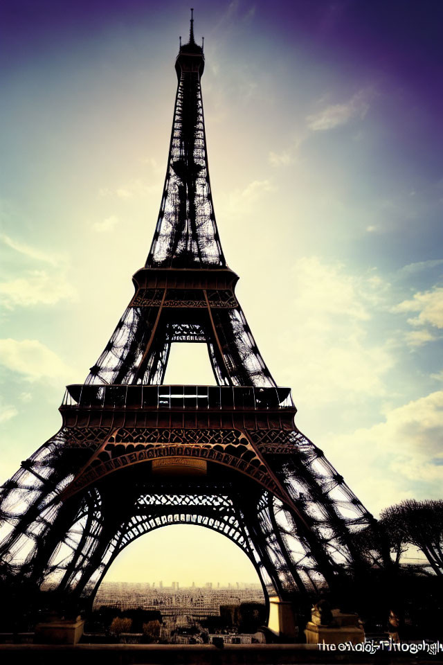 Eiffel Tower silhouette against purple and yellow dusk sky