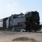 Colorful locomotive and passenger car on railway tracks in industrial setting