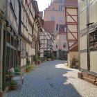 Colorful Half-Timbered Houses on Cobblestone Street Under Blue Sky