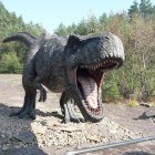 Robotic Tyrannosaurus rex Models in Misty Forest Clearing