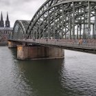 Misty scene with old metal bridge and red-roofed building