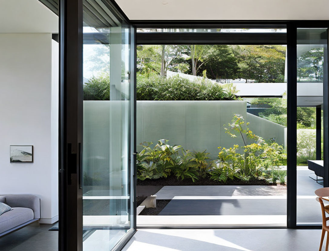 Contemporary interior with large glass doors overlooking landscaped garden