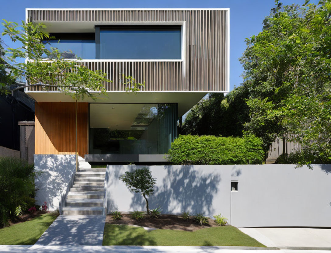 Spacious two-story house with large windows and balcony, set in lush green surroundings.